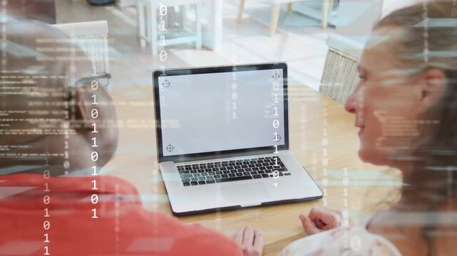 Couple sitting at table, woman waving over laptop, activating glitch overlay while testing tech