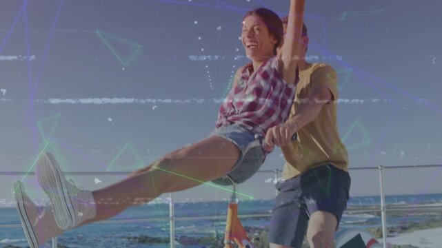 Man pedaling orange bike coast, woman legs out pair smiling, frame widening, neon overlaying travel