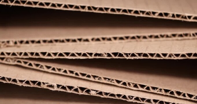 The packaging is stored in a stack, the ends of the cellulose packaging with a wavy profile and small particles of cellulose under side lighting with an authentic look and organic texture.