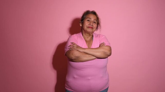 Empowered Senior Latina Woman Crossing Her Arms on Pink Background