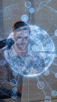 Vertical video: Man using laptop starting rotating AR globe over screen linking net nodes for tech