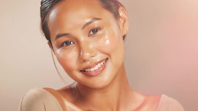 Close up video of a smiling woman with dewy glowing skin highlighting natural beauty and radiant complexion