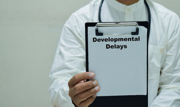 Doctor holds in hands a clipboard with the name of the developmental delays. Medical concept