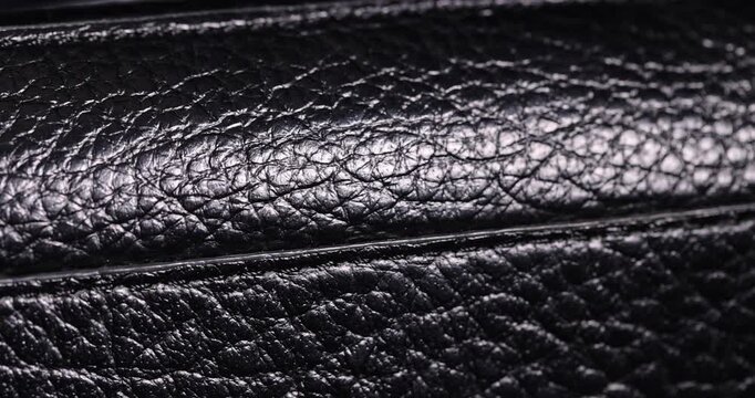 details of a natural black leather bag after prolonged use, details and pieces of natural leather used for the production of items, material