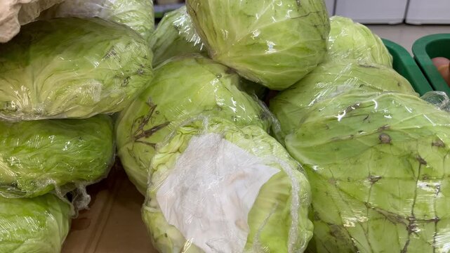 Fresh green cabbage wrapped in plastic close up