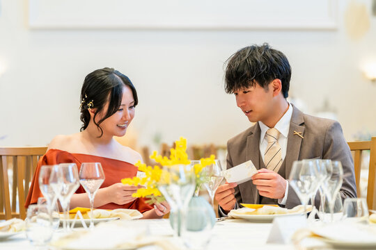 Guests, both male and female, looking at escort cards at their tables during a wedding reception.