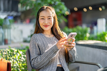 Fototapeta premium Social media, Happy asian woman using smartphone for chatting online at cafe, Smiling female user enjoying online communication, Digital internet lifestyle and mobile network connection concept