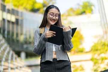 Education concept, Happy asian female university student reading educational book, Smiling young woman enjoy studying and learning, Higher education, academic knowledge, college campus and lifestyle © Art_Photo