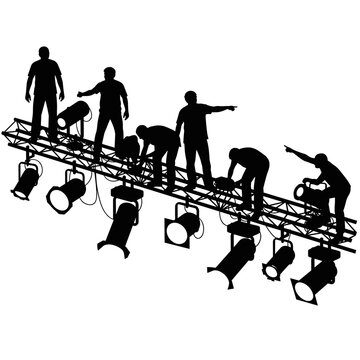 Silhouettes of Stage Technicians and Crew Rigging Professional Lighting Equipment on a Metal Truss for an Event Production