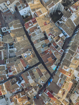 Aerial view of the dense cluster of traditional houses with terracotta rooftops and narrow alleys in the old town of La Vila Joiosa, Valencian Community, Spain.