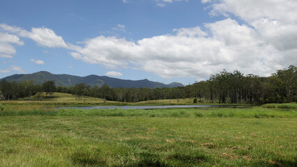 Obraz premium Serene Landscape with a Small Lake and Distant Blue Mountains