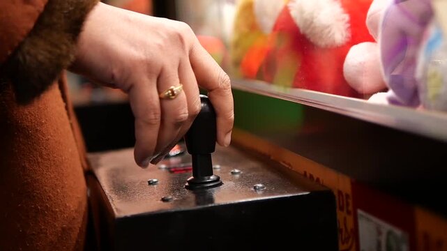 Player uses joystick to win toys at claw machine game