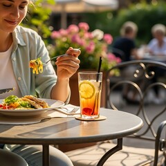 Fototapeta premium Woman Enjoying Lunch and a Drink at an Outdoor Cafe.
