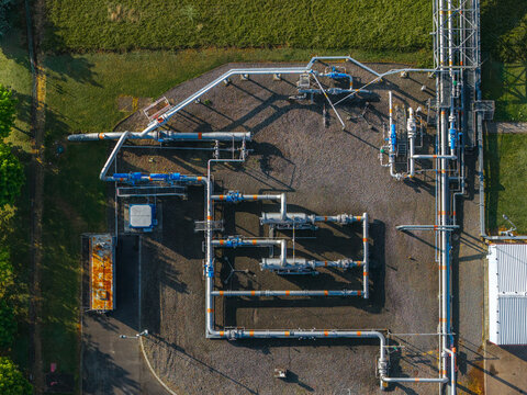 Aerial view of the UGS Damborice facility featuring complex industrial pipelines, valves, and infrastructure on gravel ground surrounded by green grass in Damborice, South Moravian Region, Czechia.
