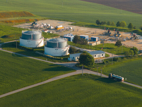 Aerial view of UGS Damborice gas storage facility with large tanks and pump jacks surrounded by green fields Damborice, South Moravian Region, Czechia.