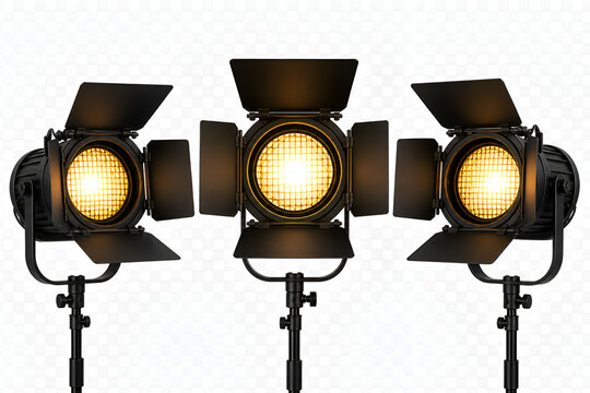 Three black professional studio continuous lights on stands with barn doors turned on, glowing warmly. Photography and videography lighting equipment isolated on a transparent background.