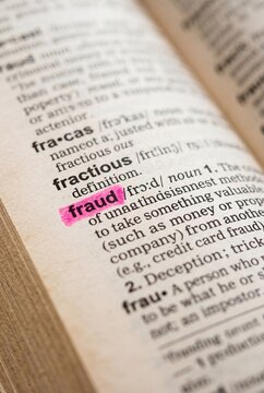 Fraud definition highlighted in dictionary with pink marker