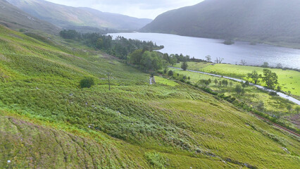 Naklejka premium Aerial View of a Lush Green Valley and Loch in Scotland