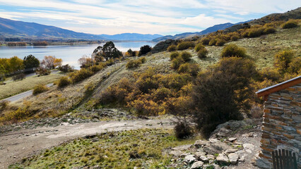 Naklejka premium Aerial view of Lake Dunstan with stone cabin and autumn foliage