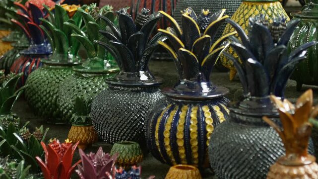 Colorful decorative pineapples and fruit ornaments arranged in market display, handmade crafts