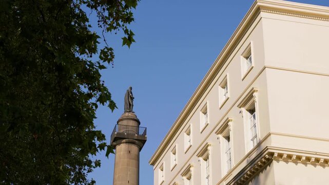 Low-angle shot of the iconic Duke of York Column and statue framed against the grand white fa&ccedil;ade of The Royal Society building on Carlton House Terrace, London. Shot 01