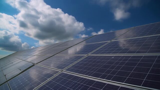 Solar panels installed on a rooftop under a cloudy blue sky