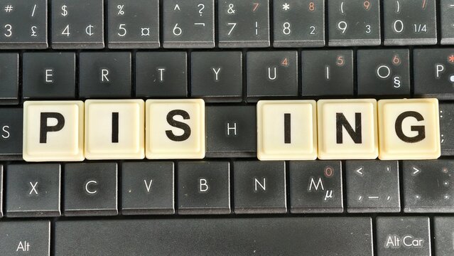 Letter tiles on a black laptop keyboard spell "PISHING," highlighting cyber threats where attackers use deceptive digital communications to steal sensitive personal information and credentials.
