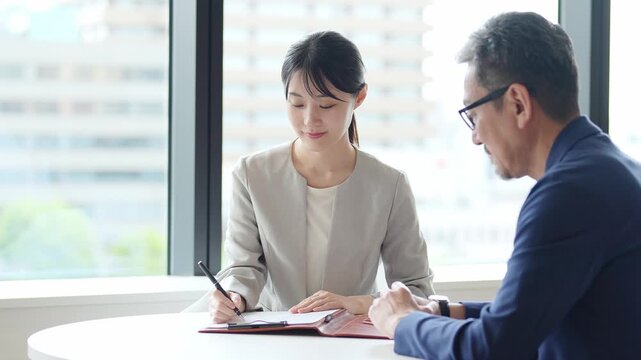 契約書にサインをする女性