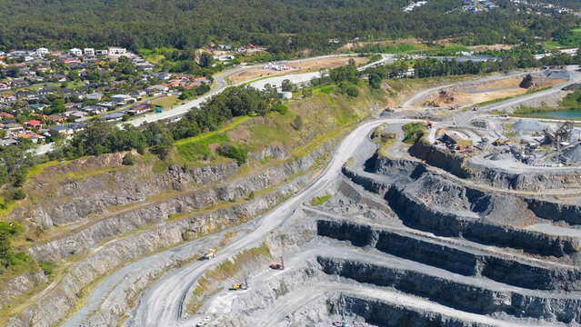 Aerial View of a Large Terraced Quarry Near a Residential Area