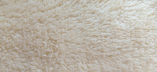 Creamy white faux fur texture, soft fluffy sheepskin rug background, cozy beige wool fabric material for winter fashion and interior design © Arbaz
