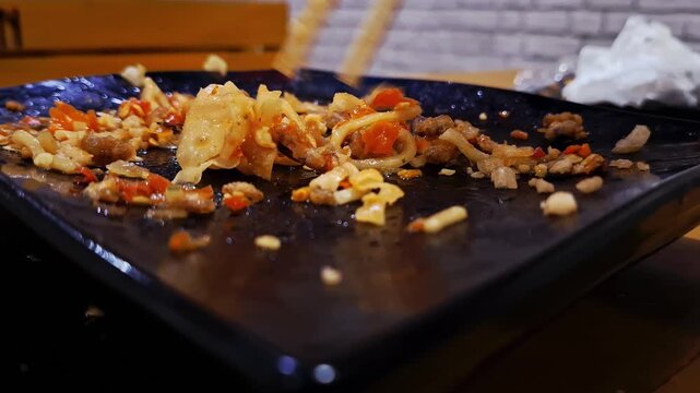Dirty plate and chopsticks after eating Indonesian spicy yellow wheat noodles with chewy texture, made from flour and eggs, served in a style similar to ramen and traditional chicken noodles.