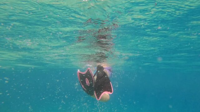 Woman swimming with fins in the transparent turquoise ocean at Sunset Beach, Mahe, Seychelles 60fps
