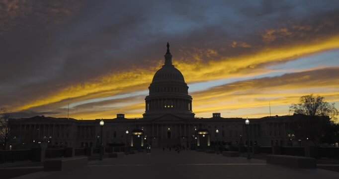 People Ride Bicycles Outside US Capitol Building at Sunset