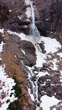 Vertical, aerial: Engstligen Falls near Adelboden during the day, second highest fall in Switzerland, crane up drone shot