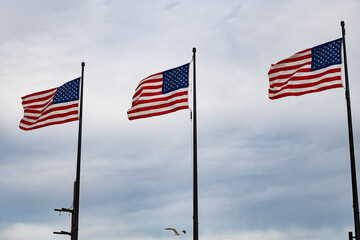 Obraz premium American Flag for Memorial Day or 4th of July. American flag waving in the wind. Flag of the USA. National waving flag of united states on blue sky. Independence day. Patriotic symbol