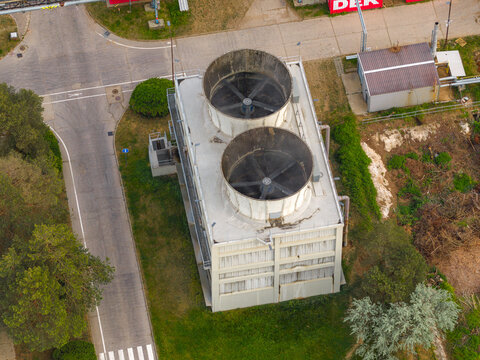 Aerial view of an industrial cooling tower with two large ventilation fans and surrounding infrastructure in Breclav, South Moravian Region, Czechia.