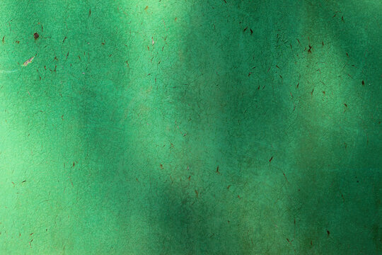 Green painted old iron wall background with stylish fine cracked texture