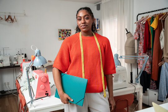 Black colombian woman fashion designer at atelier with measuring tape