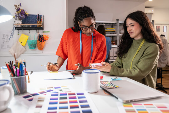 Multiethnic women plan sewing project in fashion atelier