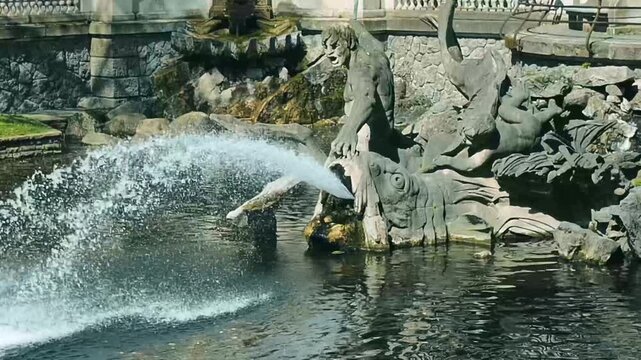 Triton Fountain in the center of D&uuml;sseldorf shows water flowing and splashing during a sunny day