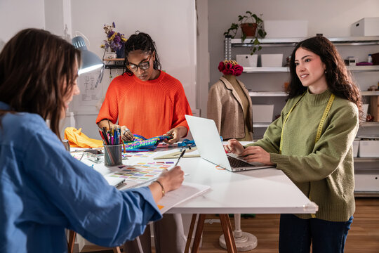 Multiethnic women designing and sewing in a fashion studio