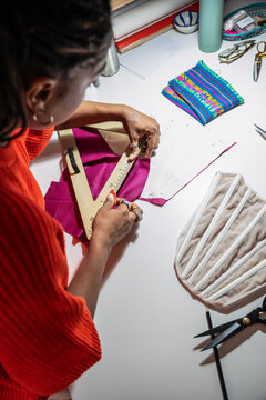 Woman pattern cutting fabric at a fashion atelier workspace