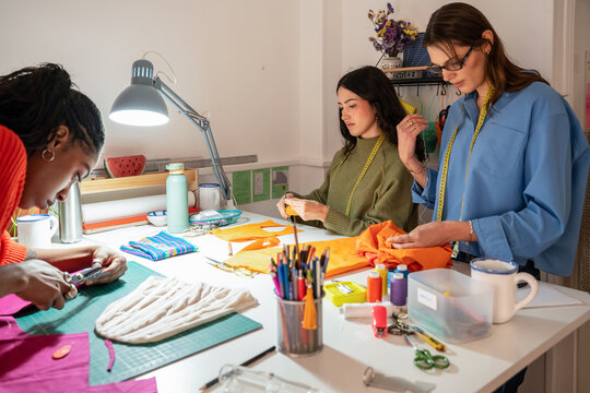 Multiethnic women sewing garments in a fashion atelier