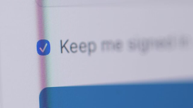 Macro 4K shot of a mouse cursor ticking an empty checkbox for "Keep me signed in" on a login interface, turning it into a blue checkmark.