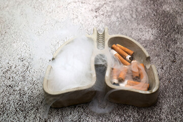 Lung shaped ashtray showing cigarette butts and smoke © vetre