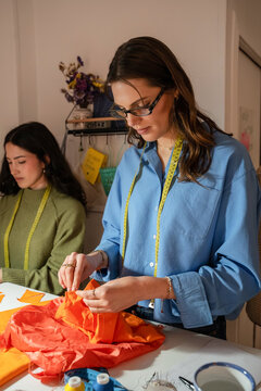 Multiethnic women sewing garments in a small atelier