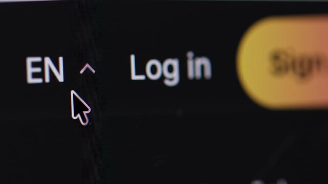 Macro 4K shot of a cursor clicking the "EN" language code next to a login button, highlighting it before opening a drop-down menu.