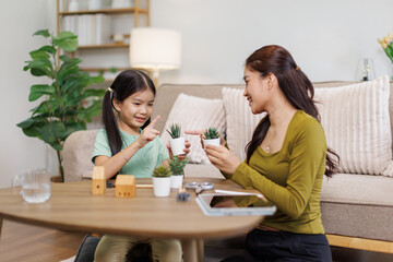 Fototapeta premium Asian mother and daughter enjoying indoor gardening hobby