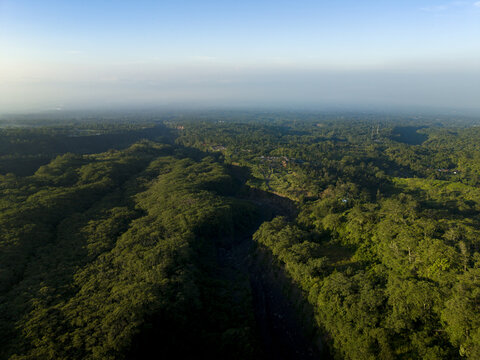 Aerial view of Bunker Kaliadem Merapi surrounded by dense tropical forest and a deep volcanic ravine under a clear sky Kecamatan Pakem, Daerah Istimewa Yogya, Indonesia.