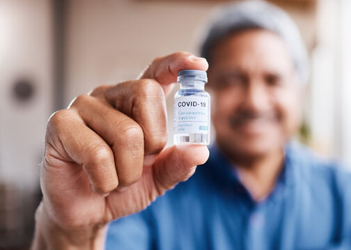 Covid, vaccine and hand with old man for medical, wellness or medicine for illness. Disease, healthcare and senior person with drugs bottle for virus, safety or risk to immune system and treatment